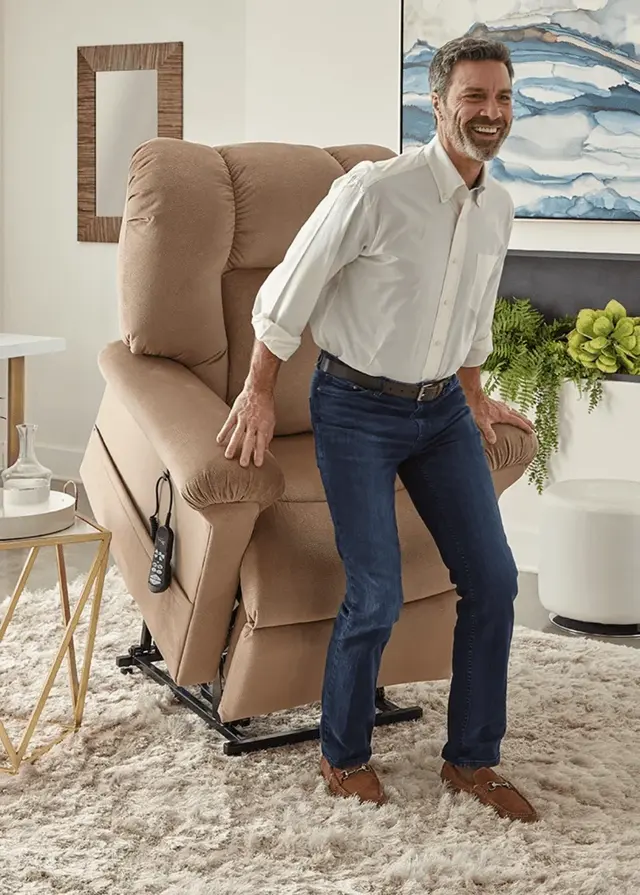 Man standing up from a tan lift chair raised in the lift position